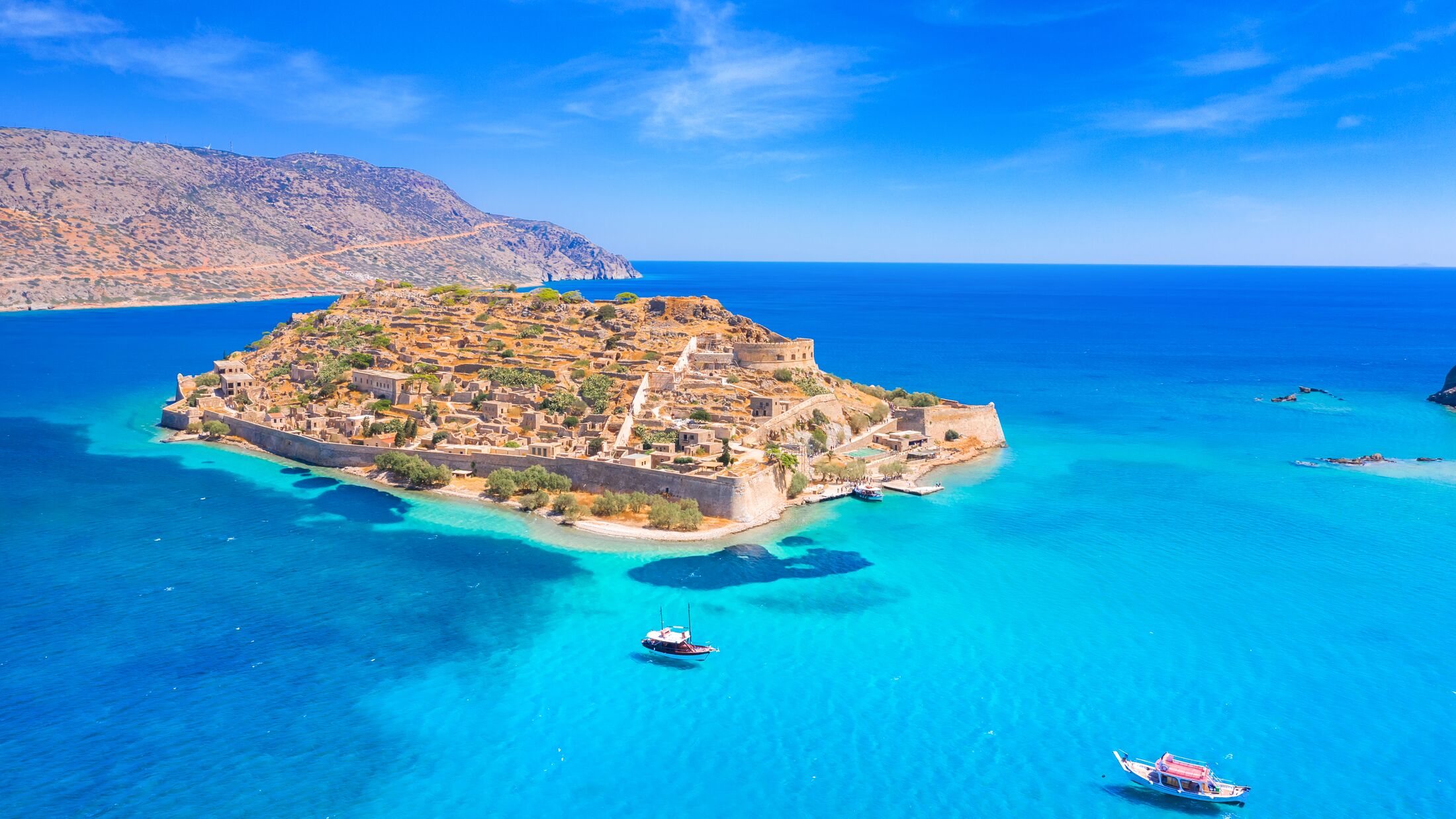 View of the island of Spinalonga with calm sea. Here were isolated lepers, humans with the Hansen's desease, gulf of Elounda, Crete, Greece.