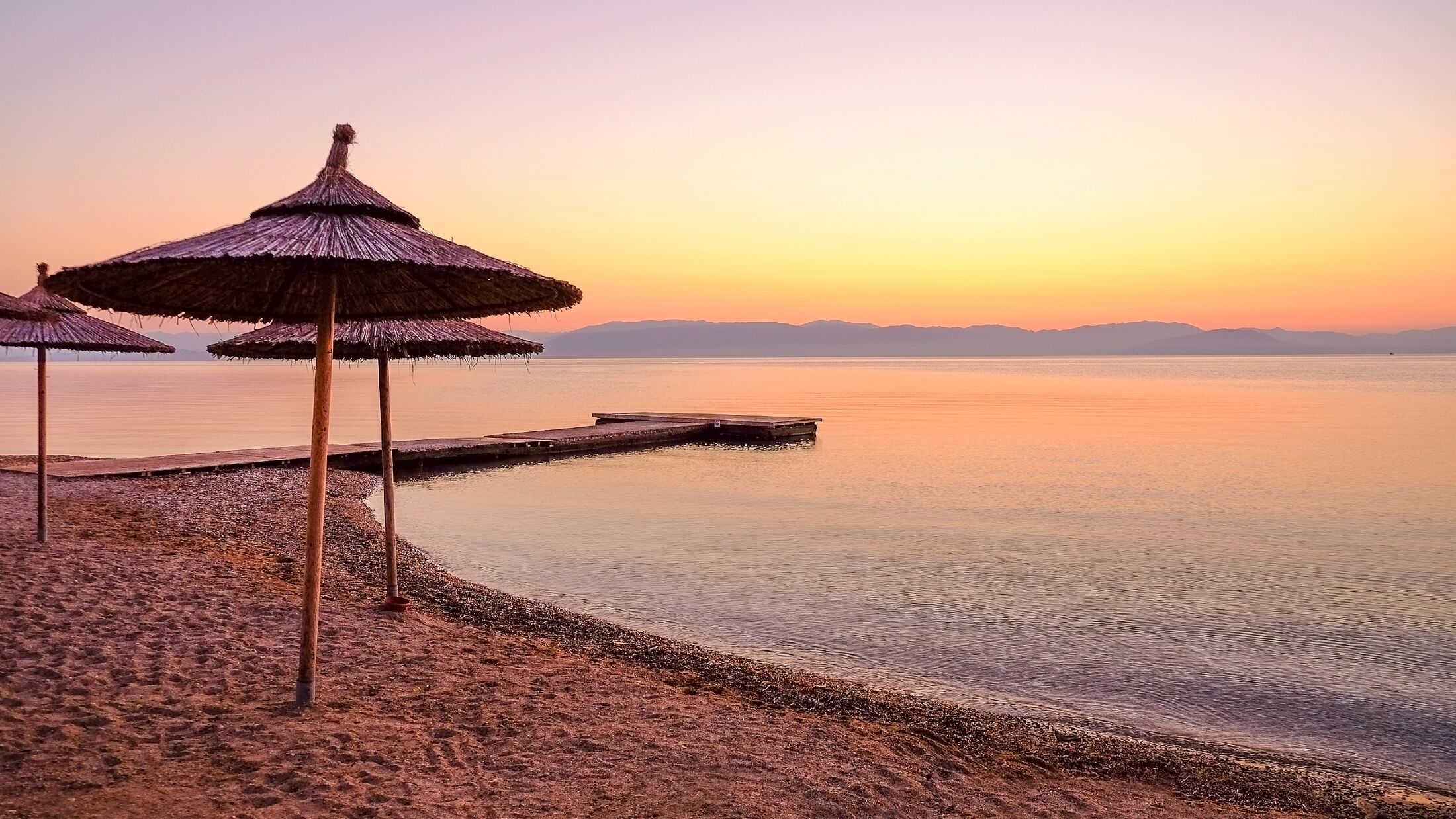 View on the beach in Moraitika with sun umbrellas on the sunrise on the the island Corfu, Greece.
