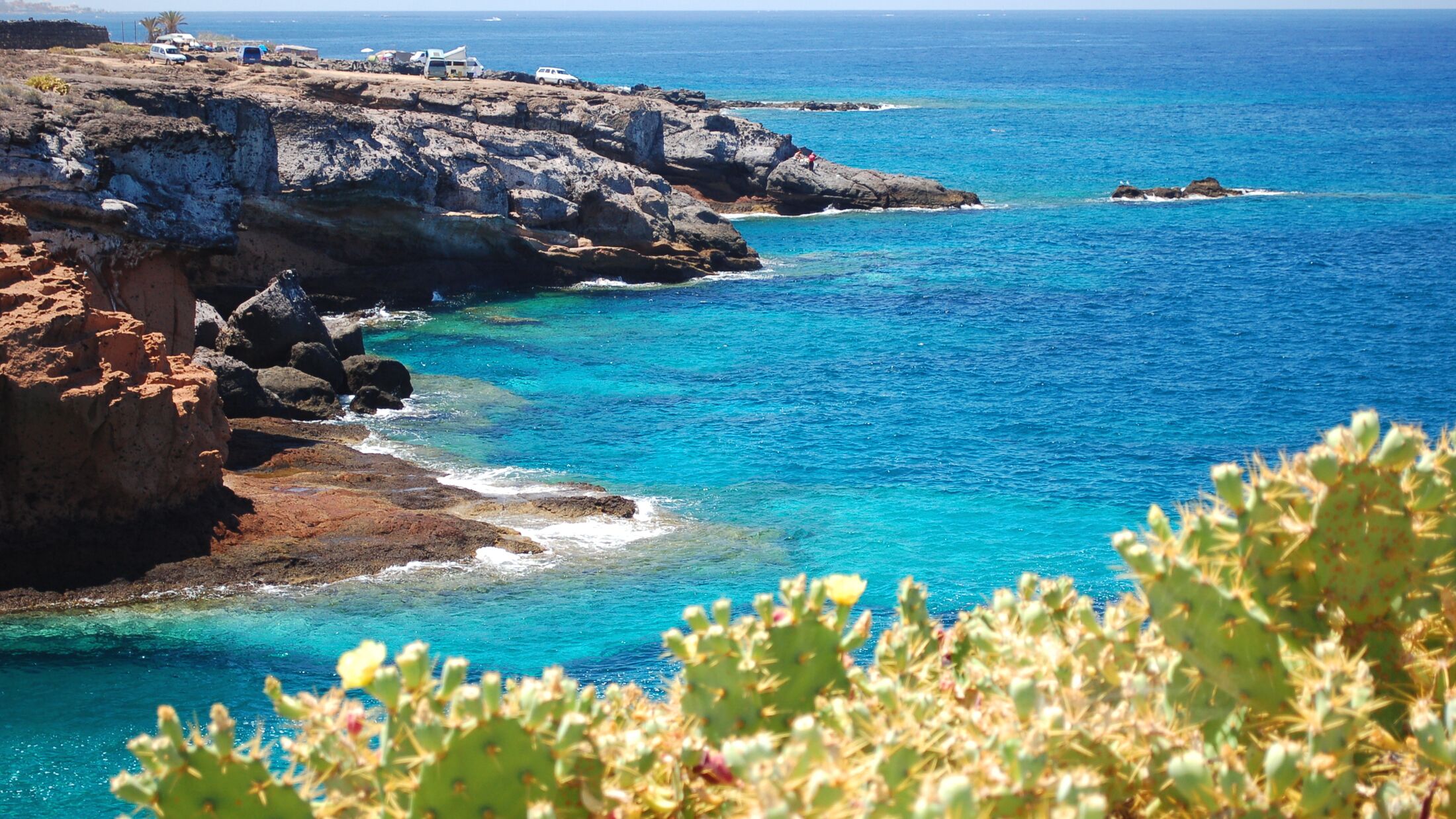 Turquoise bay and volcanic cliffs in Playa Paraiso on Tenerife, Spain